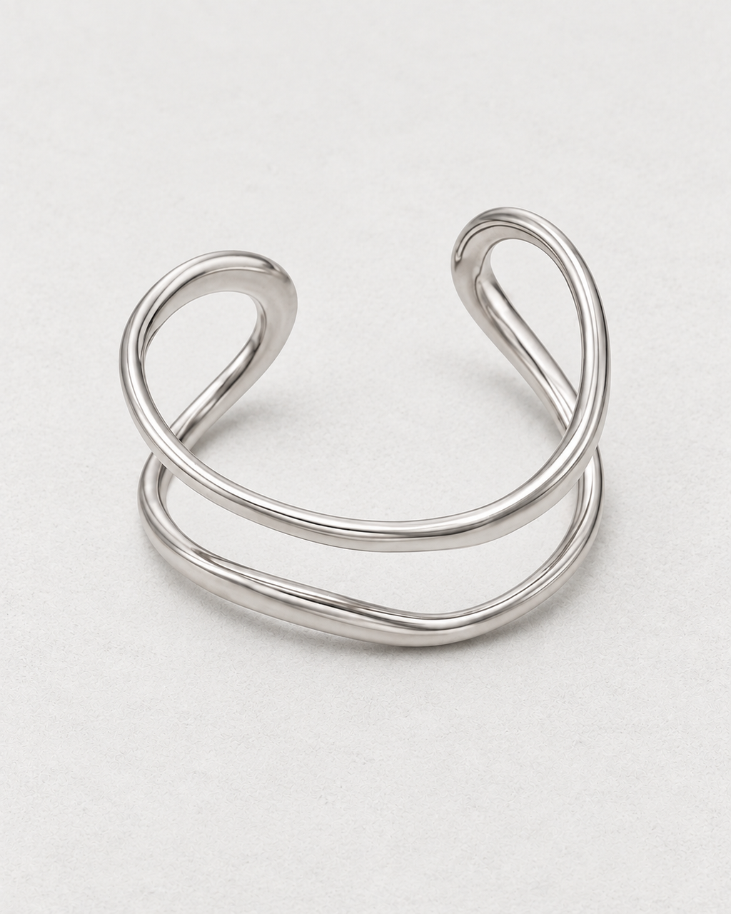 PARLX Double Loop Cuff in polished steel on light concrete — supplier-referenced rendering