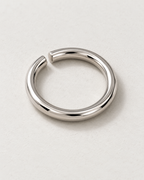 Offset Ring — Polished steel — rounded open band on pale concrete