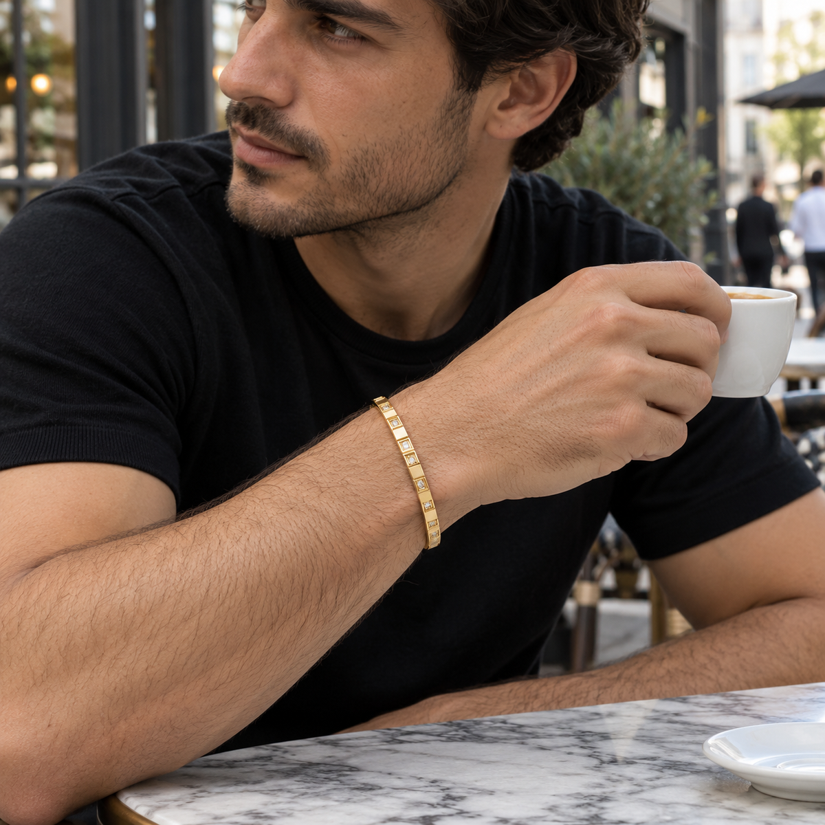 PARLX Pavé Cuff in subtle champagne yellow gold tone — generated man at an outdoor café lifestyle image
