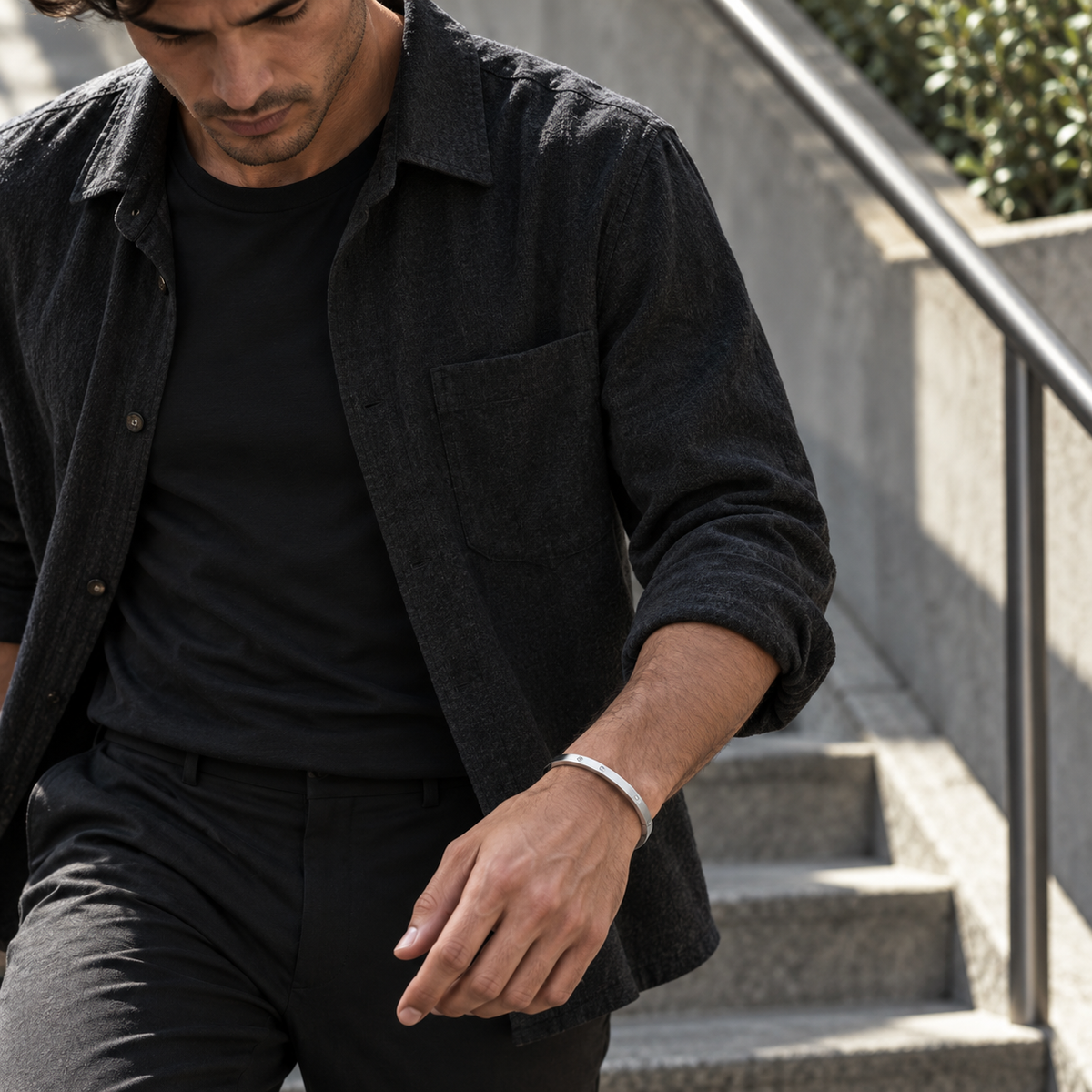 PARLX Solitaire Cuff in steel, worn by a man on city steps — generated lifestyle image